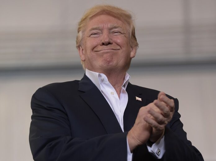 President Donald Trump smiles as he prepares to speak at his