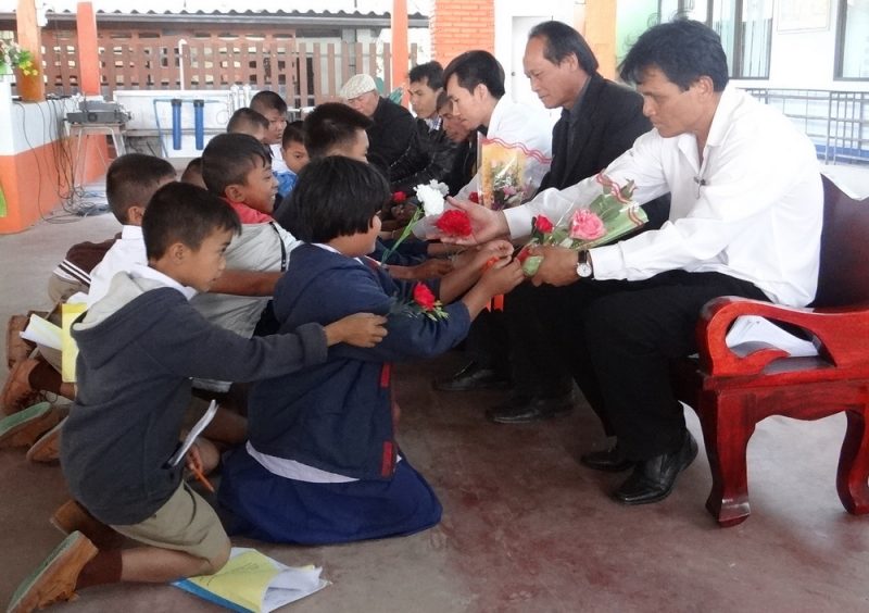 Students give roses to teachers at a school in Roi Et.