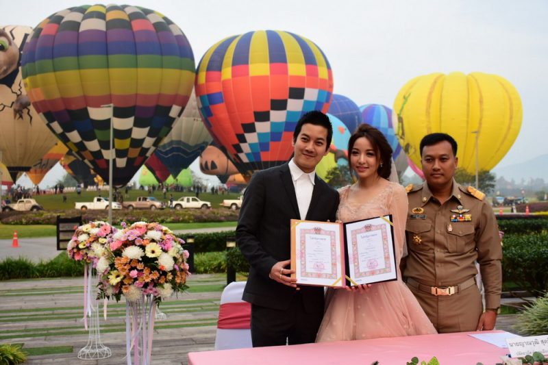 A marriage registration event in Chiang Rai takes place next to an international hot air balloon festival. 