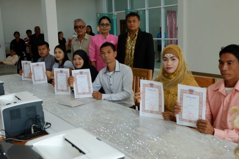 Buddhist and Muslim couples register their marriages side by side in Krabi.