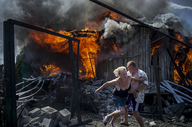 "Black Days Of Ukraine" by photographer Valery Melnikov for Rossia Segodnya, which won first prize in the Long-Term Projects category of the World Press Photo contest shows civilians escaping from a fire at a house destroyed by an air attack in the Luhanskaya village. Photo: Valery Melnikov / Associated Press