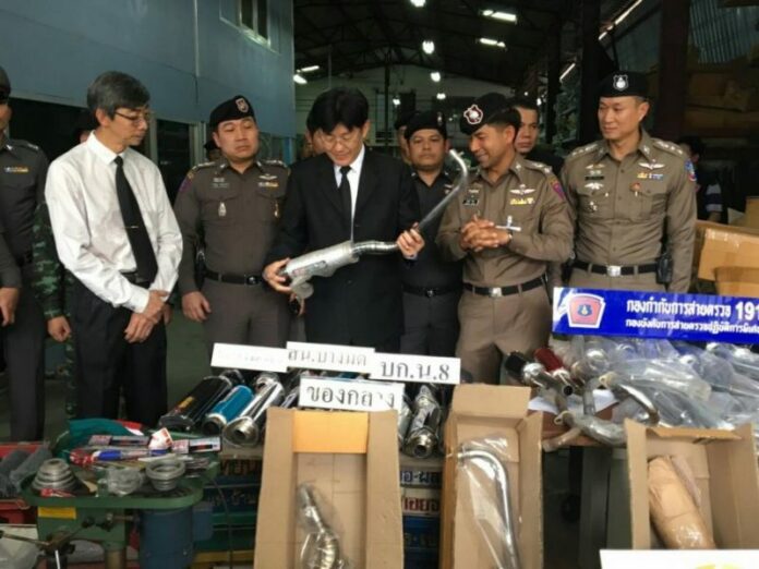 Police and industrial standard officials at the illegal exhaust pipe factory in Chom Thong Thursday afternoon.