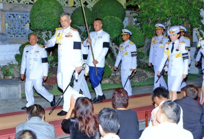 His Majesty the King sprinkles holy water on a crowd at the Grand Palace on Monday night.