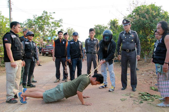 Thanapol Singto performs in a police ‘re-enactment’ of his alleged crime. He’s accused of murdering his cousin during an argument over whether former Dhammakaya abbot Dhammachayo would be found.