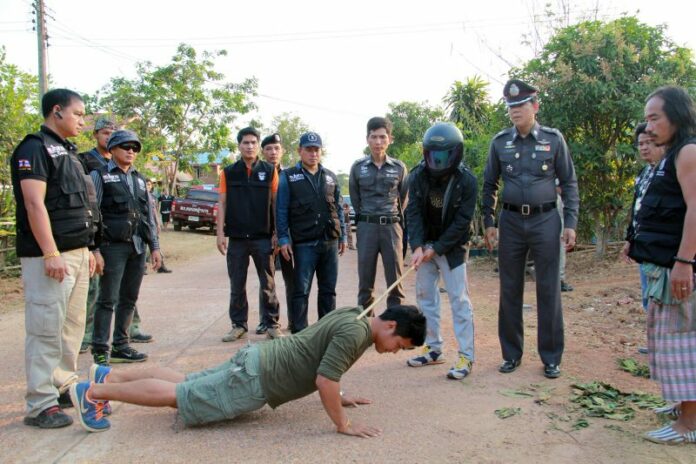 Thanapol Singto performs in a police ‘re-enactment’ of his alleged crime. He’s accused of murdering his cousin during an argument over whether former Dhammakaya abbot Dhammachayo would be found.