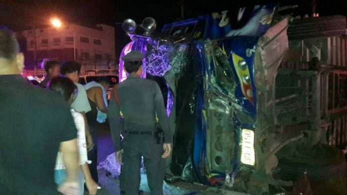 Police and passers-by at the scene of a crash which killed the driver of a bus and injured 20 others Wednesday night in Lopburi province.