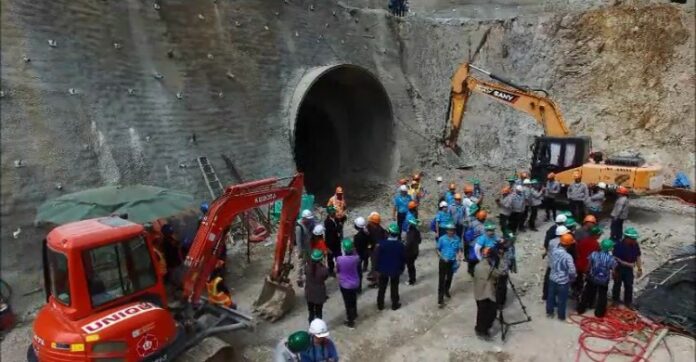 Rescue officials and workers around the tunnel that collapsed, killing two geologists Thursday morning in Chiang Mai.