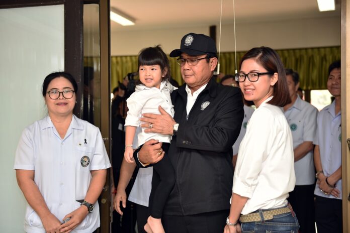 Junta chairman Prayuth Chan-ocha holds a toddler during a Thursday visit of a pediatric clinic in Prachinburi province.