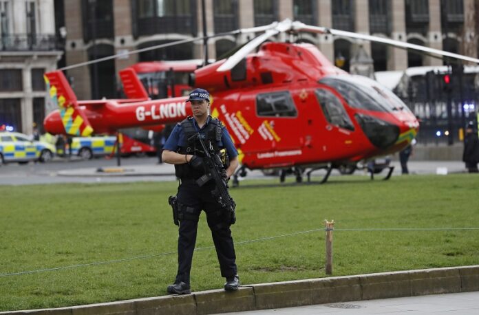 An armed police officer stands on Parliament Square outside of the Houses of Parliament on Wednesday in London. Photo: Associated Press / Kirsty Wigglesworth