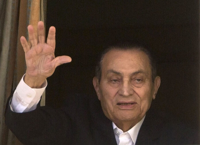 Ousted Egyptian President Hosni Mubarak waves to his supporters from his room at the Maadi Military on April 25, 2016. Photo: Amr Nabil / Associated Press