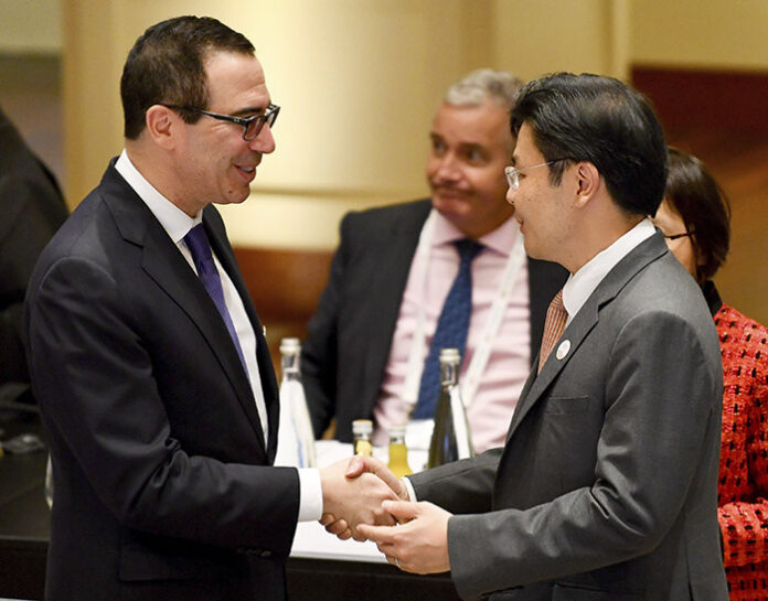 U.S. Treasury Secretary Steven Mnuchin, left, shakes hands with Lawrence Wong, Singaporean minister for national development, at the G20 finance ministers meeting in Baden-Baden, southern Germany, on Friday. Photo: Uwe Anspach/ Dpa
