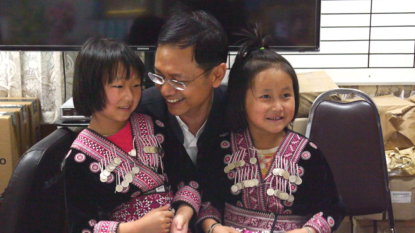 Tuesday at Chiang Mai City Hall, Chiang Mai Gov. Pawin Chamniprasart poses with two young Hmong girls who were branded by British tabloids as thieves at a meeting between their family and British Consulate representatives.