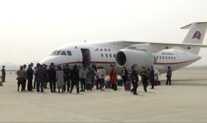 Tourists walk down from Air Koryo flight JS 782 onto the tarmac Tuesday at Sunan airport in Pyongyang, North Korea. Image: Associated Press