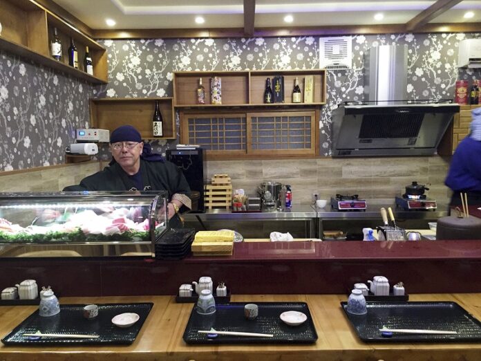 Japanese sushi chef Kenji Fujimoto works behind the counter of his new restaurant in Pyongyang, North Korea. Photo: Associated Press