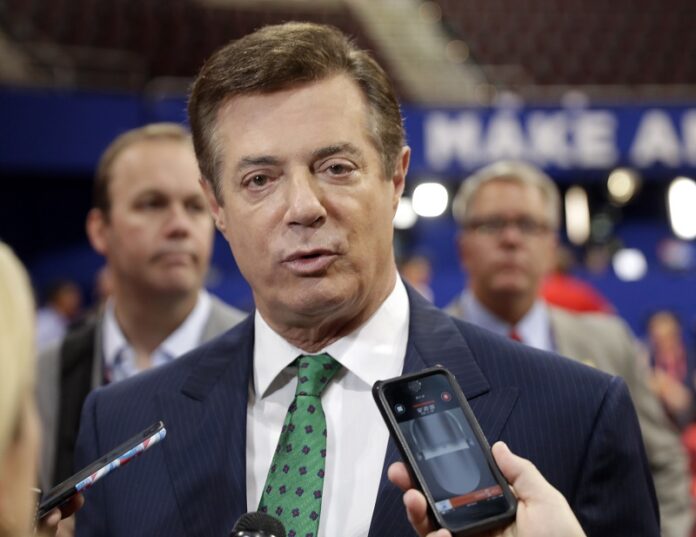 Trump campaign chairman Paul Manafort talks to reporters in 2016 on the floor of the Republican National Convention at Quicken Loans Arena in Cleveland as Rick Gates listens at back left. Photo: Matt Rourke / Associated Press