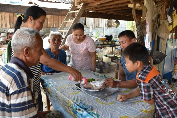 Neighbors in Uttaradit province rub the bodies conjoined piglet twins Wednesday for lottery numbers.