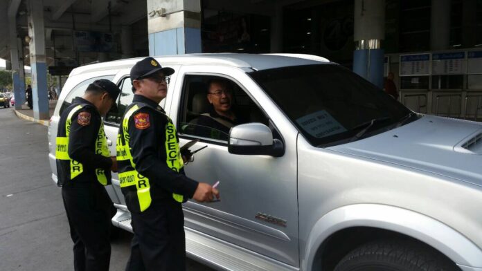 Police stop an Uber driver Monday in Bangkok. Photo: Matichon