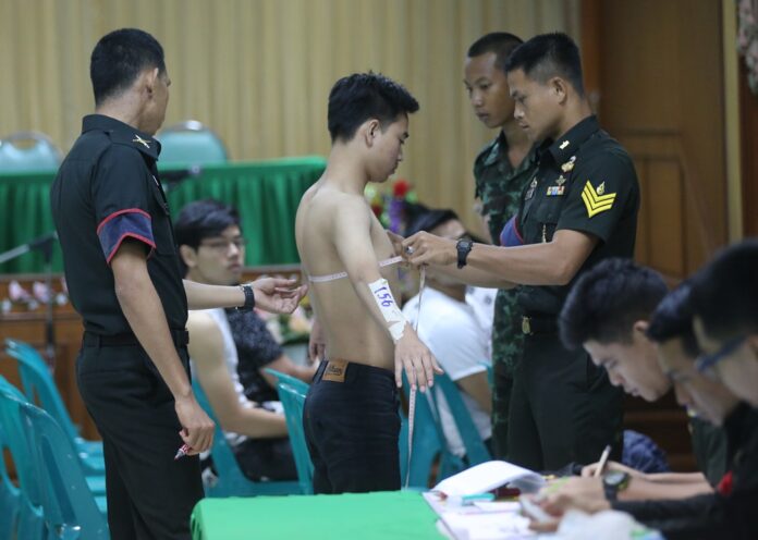 Army recruiters inspect potential draftees in Bangkok on Saturday