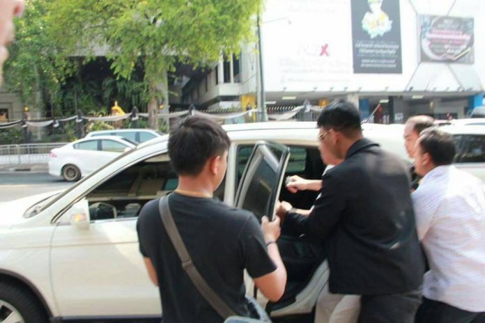Ekachai Hongkanwan seen here Tuesday morning as he is taken into a nondescript vehicle in front of Government House. Photo: Piyarat Chongthep / Facebook