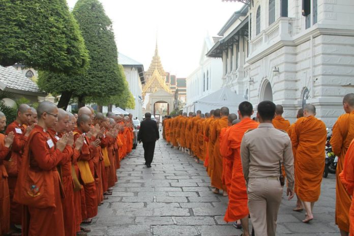 Women monks, barred from entering the Grand Palace to honor King Bhumibol, pay their respects to the male monks entering the grounds in December. Photo: Matichon