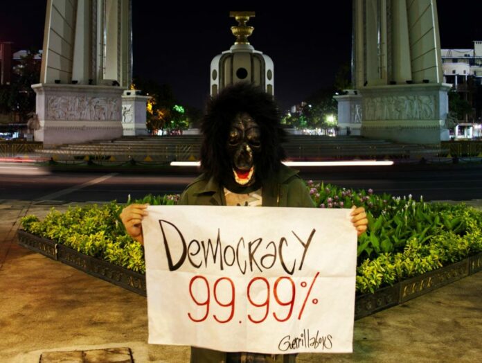 A member of art-activist group Guerrilla Boys in a photo from Aug. 6 at the Democracy Monument critical of a statement by Prime Minister Prayuth Chan-ocha that Thailand was ‘99.99 percent democratic.’ Photo: Guerrilla Boys / Courtesy