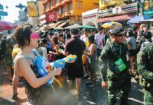 Photo Phriday: Songkran, Songkran and Songkran A woman with a Doraemon water gun backpack sprays soldiers during 2017 Songkran celebrations on Khaosan Road.