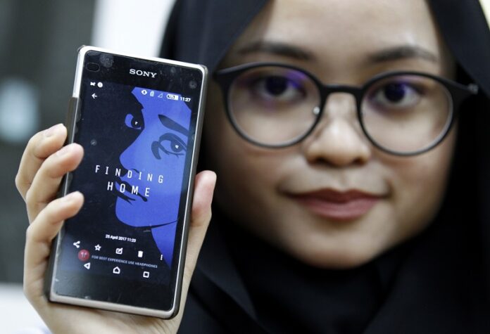 Staff member of the United Nations High Commission for Refugees Izarra Azuddin displays the application