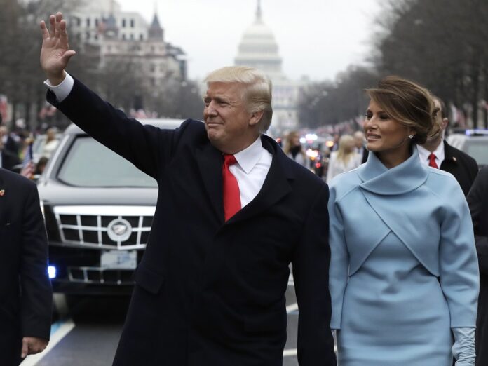 President Donald Trump waves as he walks with first lady Melania Trump during the inauguration parade in January on Pennsylvania Avenue in Washington. Photo: Evan Vucci / Associated Press
