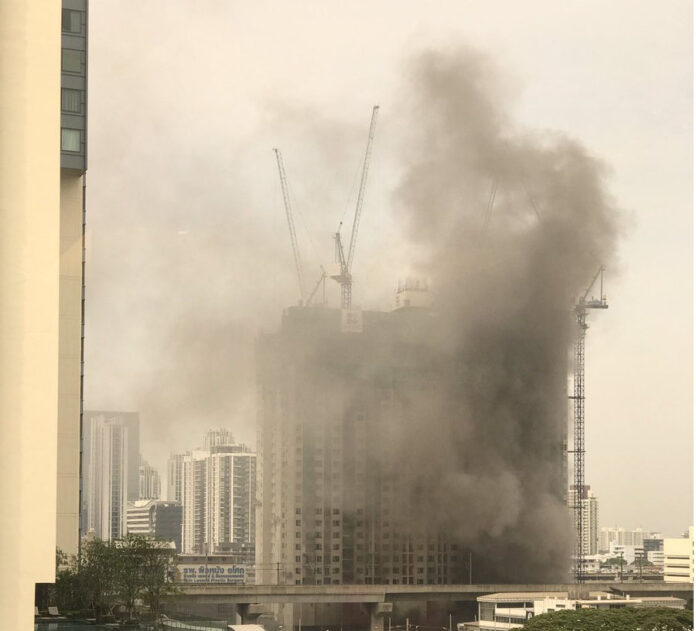 Smoke rises from a fire at the construction site of Life Asoke condo in the Huai Khwang district. Photo: @Katopz / Twitter Read: Fire at ‘Life Asoke’ Condo Project Now Under Control