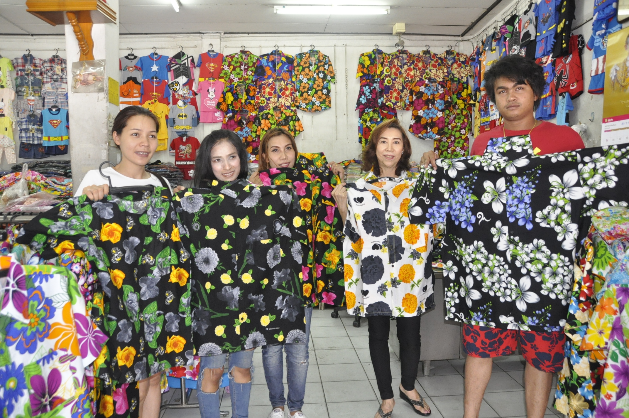 People purchase Songkran flower-patterned shirts Monday in Korat. Black shirts with white flowers are popular choices this year, vendors said. 