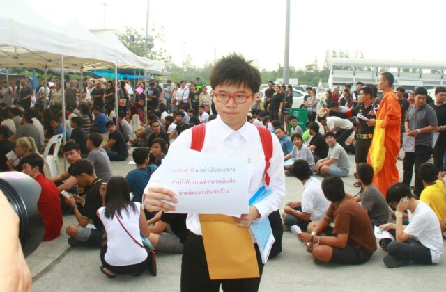 With a sign decrying the draft as "outdated and unnecessary," activist Netiwit Chotiphatphaisal defers enlistment for one year in 2017.