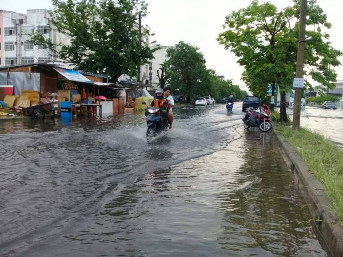 Flooded streets in Pathum Thani province Tuesday afternoon after heavy rains.