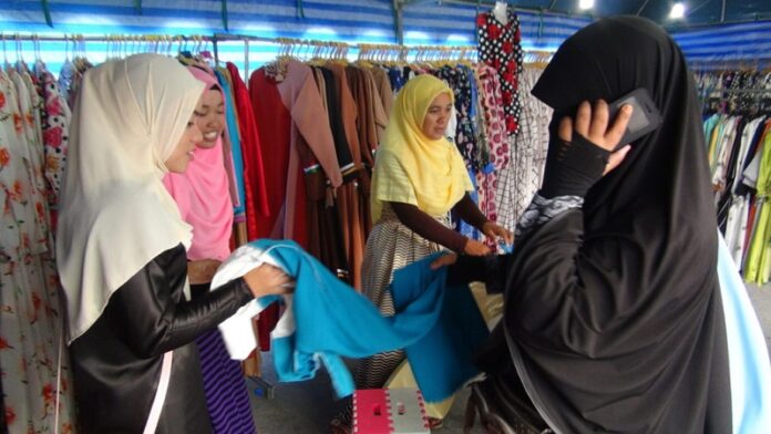 Women shop for clothes at a market in Yala province on June 29, 2016