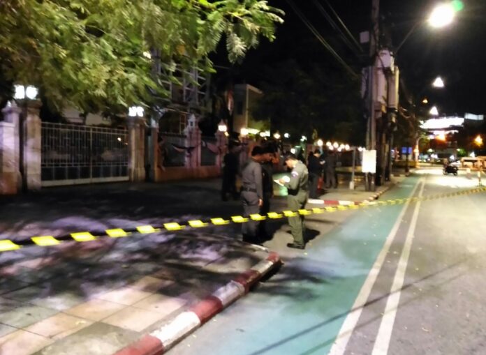 Police bomb squad officers inspect the scene in front of National Theatre Monday night, where an explosion injures 2 people.