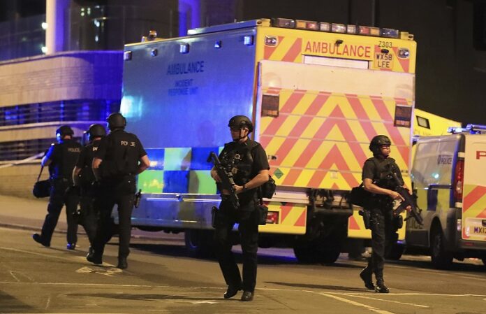 Armed police work at Manchester Arena after reports of an explosion at the venue during an Ariana Grande gig Monday in Manchester, England. Photo: Peter Byrne / Associated Press