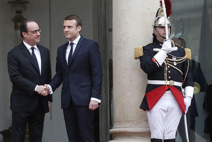 Outgoing French President Francois Hollande, at left, welcomes incoming French President Emmanuel Macron as he arrives for his inauguration ceremony at the Elysee palace in Paris on Sunday. Photo: Thibault Camus / Associated Press