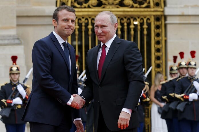 Russian President Vladimir Putin, right, and French President Emmanuel Macron pose for a photo at the Palace of Versailles, near Paris, on Monday. Photo: Alexander Zemlianichenko