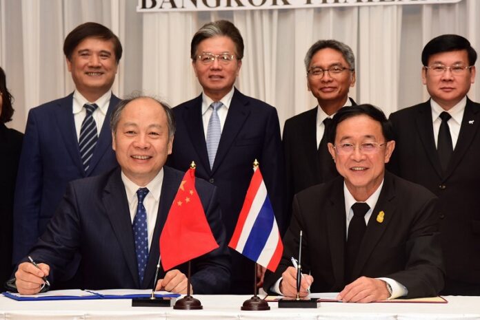 Minister Akhom Termpittayapaisit, at left, sits beside Wang Xiaotao, vice-chairman of the Chinese National Development and Reform Commission. Photo: Logisticnews / Facebook