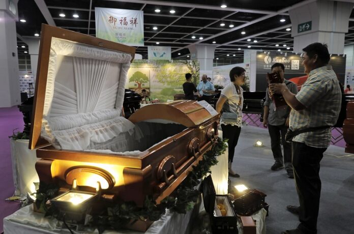 Visitors look at a paper casket at the Asia Funeral and Cemetery Expo & Conference on Thursday in Hong Kong. Photo: Vincent Yu / Associated Press