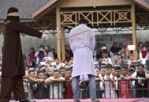 Amnesty Urges Malaysia to Quash Caning Sentence of Lesbians A Sharia law official whips a man convicted of adultery with a rattan cane in 2017 in Banda Aceh, Indonesia. Photo: Heri Juanda / Associated Press