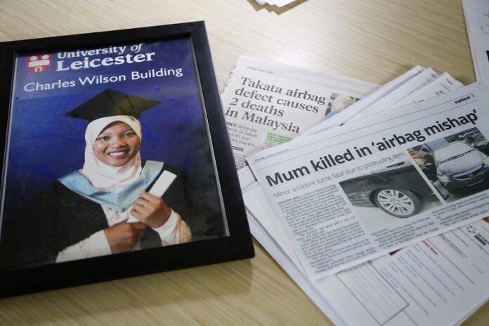 A portrait of Nida Fatin Mat Asis, a Malaysian doctor who died after being allegedly struck by a defective air bag inflator shown here last November, next to news clippings in Kuala Lumpur, Malaysia. Photo: Lim Huey Teng / Associated Press