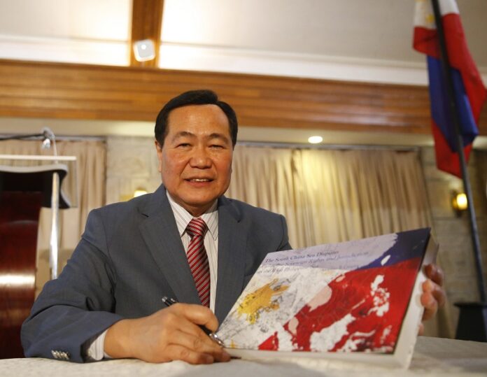Philippine Supreme Court Senior Associate Justice Antonio Carpio holds a hard copy of his e-book titled