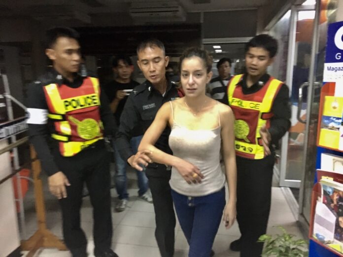 Police escort Anna Hambawaris, aka Anna Reese, to Huai Khwang Police Station after the crash Sunday night.