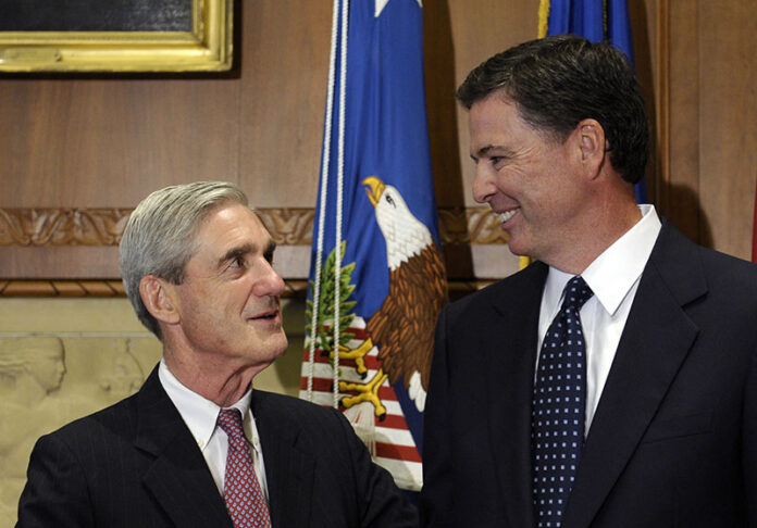 In a Sept. 4, 2013, file photo, then-incoming FBI Director James Comey talks with outgoing FBI Director Robert Mueller before Comey was officially sworn in at the Justice Department in Washington. Photo: Susan Walsh / Associated Press