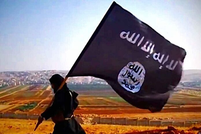 This undated photo shows an individual carrying a flag of the so called Islamic State at an undisclosed location. Photo: VOA / Wikimedia Commons
