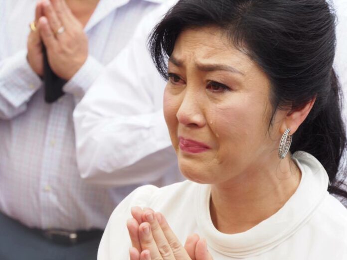 Former PM Yingluck Shinawatra cries on June 21, 2017, as she prays at the Golden Mount Temple on her 50th birthday. Photo: Charan Ampornklinkeaw