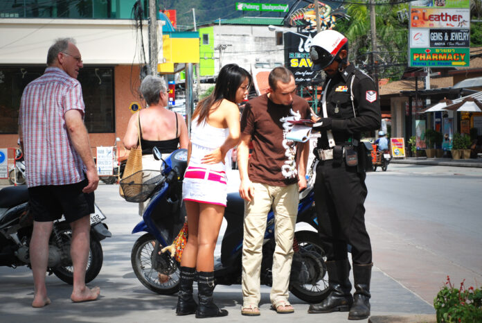 Tourists are fined for riding a motorbike without wearing helmets in 2008 in Phuket. Photo: William Cho/ Flickr.
