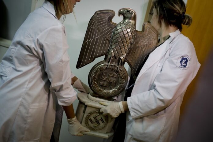 Members of the federal police carry a Nazi statue at the Interpol headquarters Friday in Buenos Aires, Argentina. Photo: Natacha Pisarenko / Associated Press
