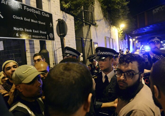 Police officers talk with local people at the Finsbury Park in north London, where a vehicle struck pedestrians Monday. Photo: Yui Mok / PA via Associated Press