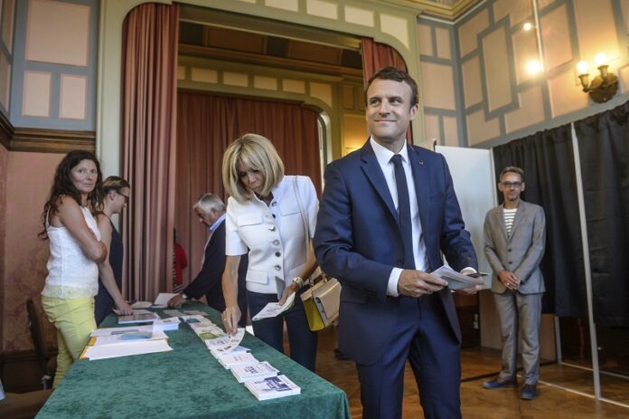 French President Emmanuel Macron and his wife Brigitte Macron pick up ballots before voting in the first round of the two-stage legislative elections Sunday in Le Touquet, northern France. Photo: Christophe Petit-Tesson / Associated Press